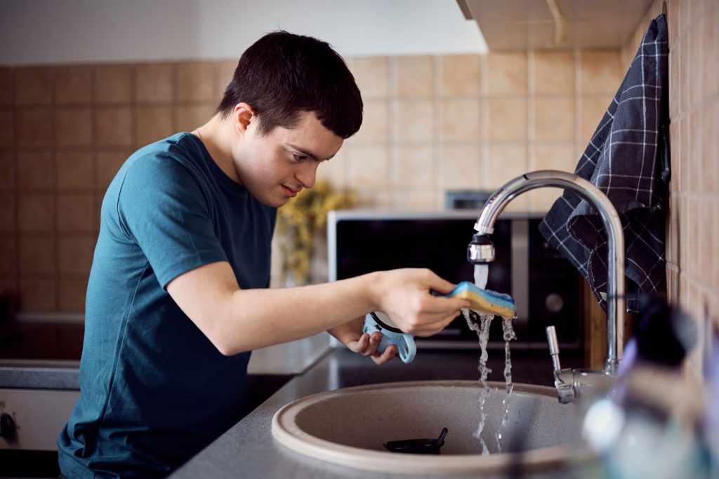Man standing at sink with running water